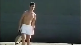 Tennis player likes to loosen his penis stiff muscles after excercises with ball shooter machine and drop his albatross on his tennis racket